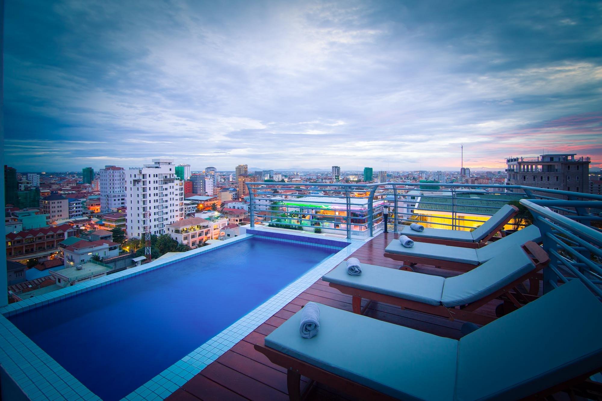 Sai&Su Hotel rooftop plunge pool with panoramic views of Phnom Penh skyline at sunset